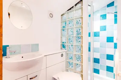 a bathroom with a white sink and a shower at Dingles Cottage in Saint Minver
