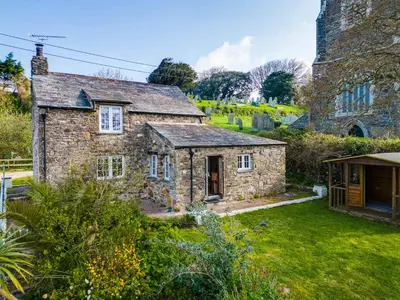 an old stone house with a garden in front of it at Dingles Cottage in Saint Minver