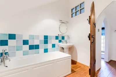 a bathroom with a tub and a sink at Dingles Cottage in Saint Minver