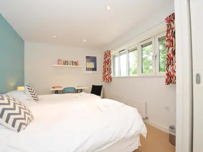 a bedroom with two white beds and a table at The Old Granary in Saint Minver