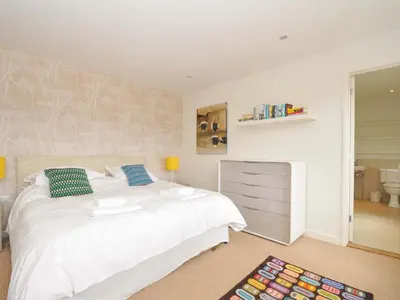 a bedroom with a white bed and a dresser at The Old Granary in Saint Minver
