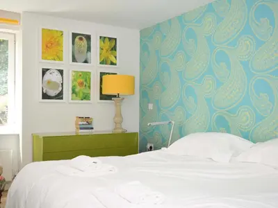 a bedroom with a bed with a blue wall at The Old Granary in Saint Minver