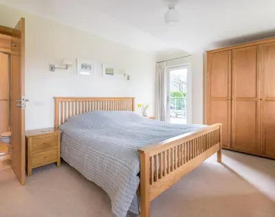 a bedroom with a wooden bed and a window at Ragleighs in Polzeath