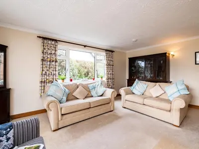 a living room with two couches and a window at Longhouse Bungalow in Polzeath