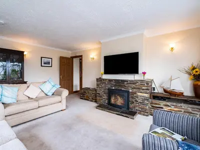 a living room with a couch and a fireplace at Longhouse Bungalow in Polzeath