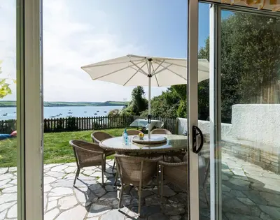 a table and chairs with an umbrella on a patio at Carn Du 1 in Padstow