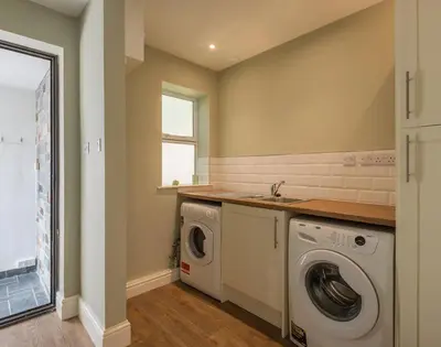 a laundry room with a washing machine and a sink at Carn Du 1 in Padstow