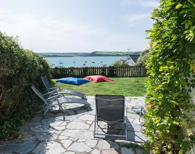 a patio with two chairs and a table at Carn Du 1 in Padstow