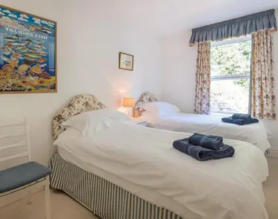 two beds in a bedroom with towels on the bed at Carn Du 1 in Padstow
