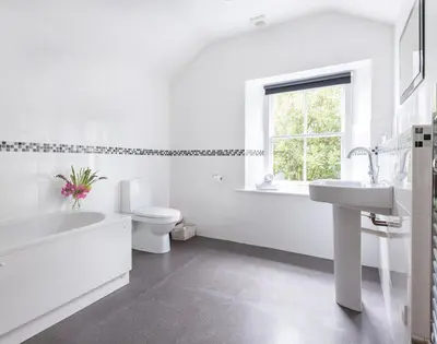 a white bathroom with a sink and a toilet at Conifers in Saint Minver