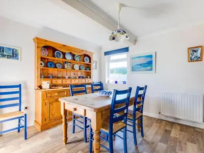 a dining room with a wooden table and chairs at Little Sailing in Padstow