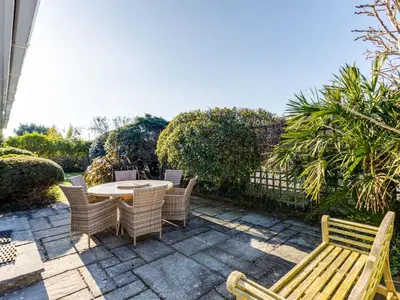 a patio with a table and chairs and a fence at Little Sailing in Padstow