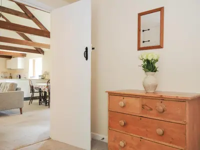 a room with a dresser with a vase of flowers on it at Mill Pond in Saint Minver