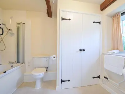 a bathroom with a toilet and a tub and a sink at Mill Pond in Saint Minver