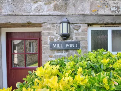 a street sign in front of a building with a window at Mill Pond in Saint Minver