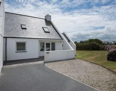a white house with a driveway in front of it at Kirra in Polzeath