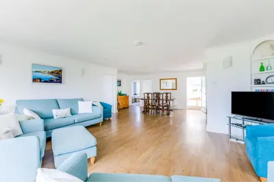 a living room with blue couches and a flat screen tv at Rock Hill in Padstow