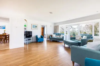 a living room with blue couches and a table at Rock Hill in Padstow
