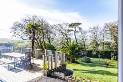 a patio with a table and chairs and a garden at Rock Hill in Padstow