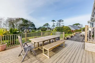 a wooden deck with a wooden table and chairs at Rock Hill in Padstow