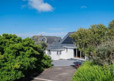 a white house with solar panels on its roof at Treverden in Polzeath