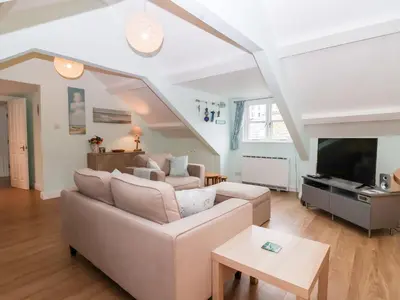 a living room with a couch and a tv at Smugglers Loft in Looe