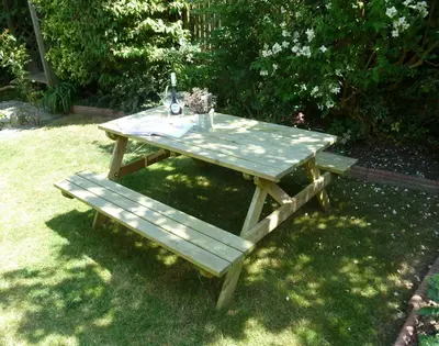 a picnic table and a bench in the grass at Fairholme in Port Isaac