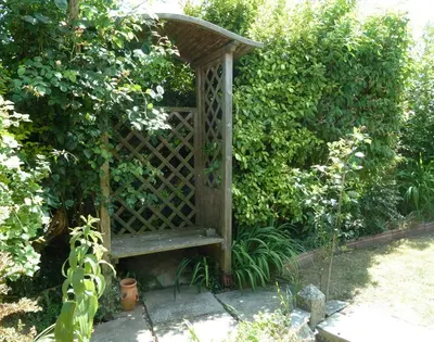 a wooden bench sitting in the middle of a garden at Fairholme in Port Isaac