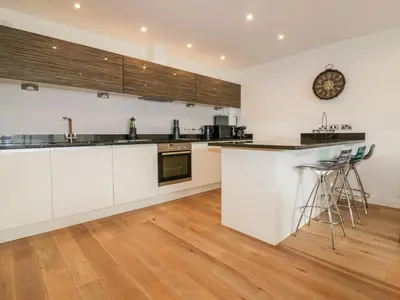 a kitchen with white cabinets and a counter at Fistral Apres Surf in Newquay