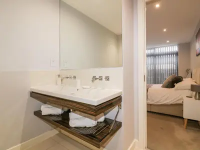 a bathroom with a sink and a bed at Fistral Apres Surf in Newquay