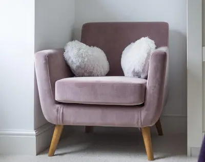 a brown chair with two fuzzy pillows on it at Beehive Cottage in Port Isaac