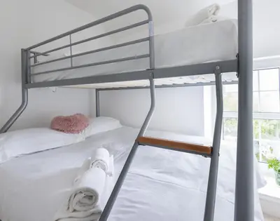 a bunk bed with towels on the bottom bunk at Beehive Cottage in Port Isaac