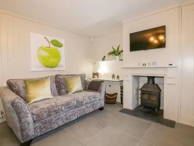 a living room with a couch and a fireplace at Apple Barn in Newquay