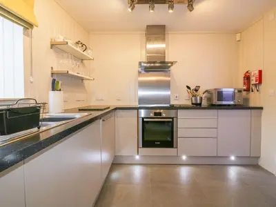 a kitchen with white cabinets and a counter top at Apple Barn in Newquay