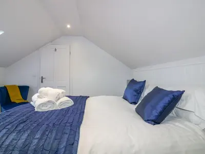 a bedroom with a bed with blue and white pillows at Apple Barn in Newquay