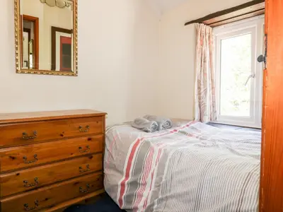 a stuffed elephant sitting on a bed next to a dresser at Little Trespettigue in Launceston