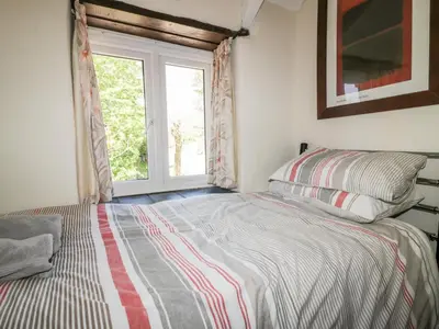 a bedroom with a bed with a window at Little Trespettigue in Launceston