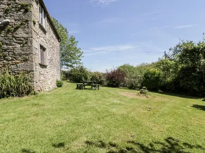 a picnic table in a yard next to a stone building at Little Trespettigue in Launceston