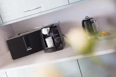 a kitchen counter with a coffee maker and a bowl of fruit at Sandbanks in Penzance