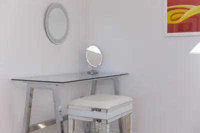 a dressing table with a mirror and a stool at Sandbanks in Penzance
