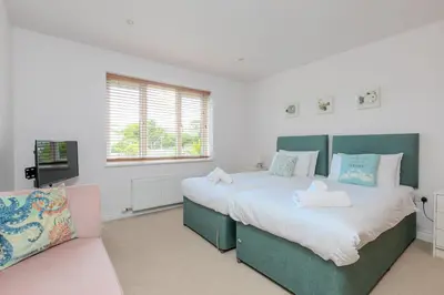 a bedroom with two beds and a couch at Sandbanks in Penzance