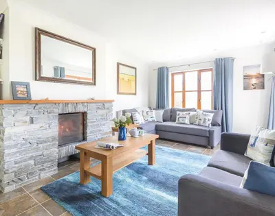 a living room with a couch and a fireplace at Lundy Cottage in Saint Minver