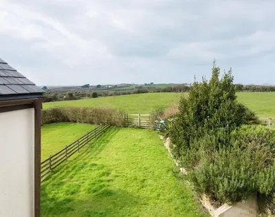 a view of a field of grass with a fence at Lundy Cottage in Saint Minver