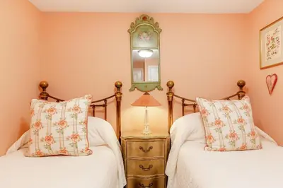 a bedroom with two beds and a mirror on the wall at Armando in Truro