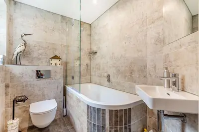 a bathroom with a tub and a toilet and a sink at Armando in Truro