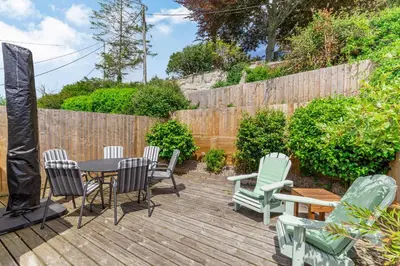a patio with a table and chairs on a wooden deck at Armando in Truro