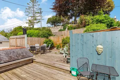 a backyard with chairs and a fence and a wooden deck at Armando in Truro