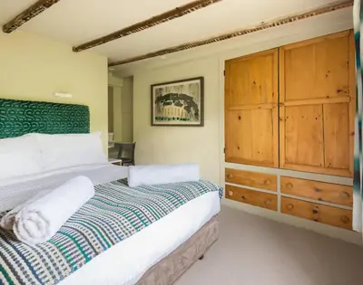 a bedroom with a large bed and a wooden dresser at Crow's Nest in Port Isaac