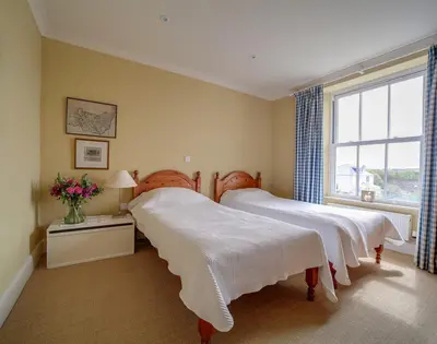 a bedroom with two beds and a window at Worthy House in Polzeath