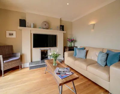 a living room with a couch and a fireplace at Worthy House in Polzeath